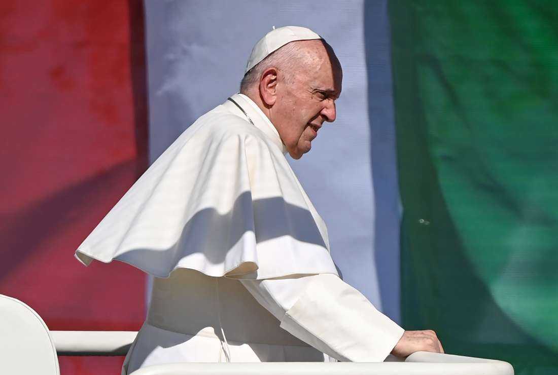 In this file photo taken on Sept. 12, 2021, Pope Francis passes by a Hungarian national flag as he takes a tour in an open vehicle to greet the faithful before a Holy Mass at the end of an International Eucharistic Congress in Budapest, during his papal visit to Hungary