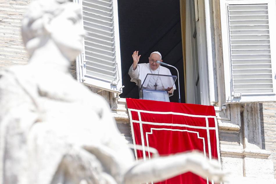 Pope Francis leads the Angelus prayer from the window of his office overlooking St. Peter