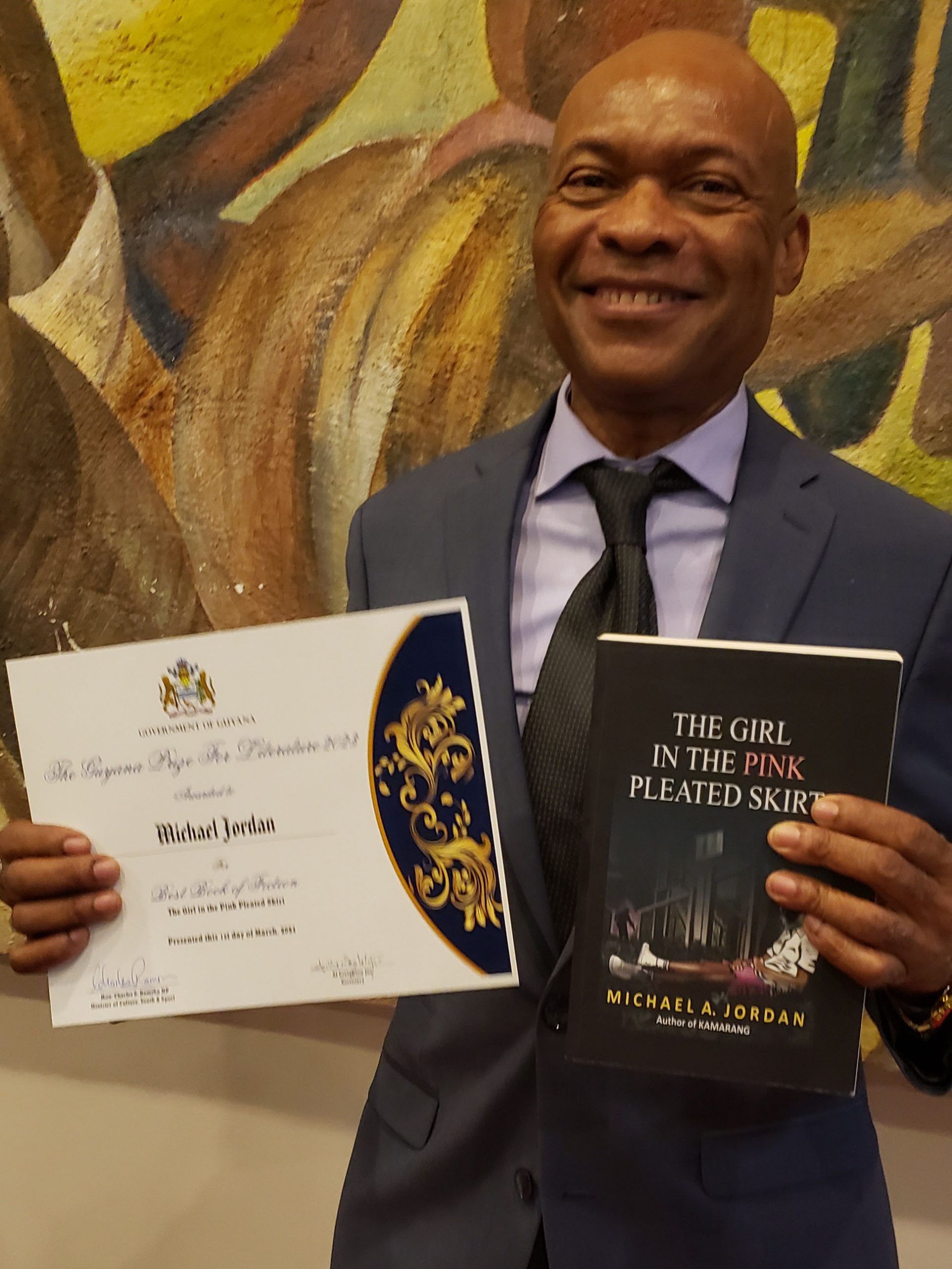 Michael Jordan poses with his award winning novel and his Guyana Prize for Literature certificate of award